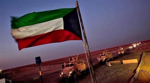 العلم الكويتي مرفرفاً بالقرب من آليات عسكرية (أرشيف)