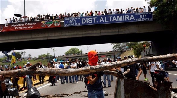 أنصار المعارضة الفنزويلية يغلقون شارعاً رئيسياً في العاصمة (رويترز)