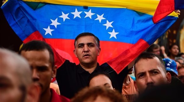 رجل يحمل علم فنزويلا خلال إحدى التظاهرات (أ ف ب)