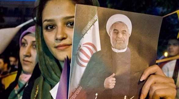 إيرانية تحمل صورة الرئيس الإيراني حسن روحاني 