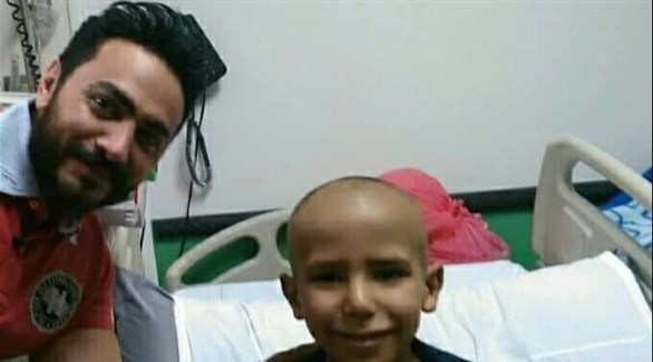 تامر حسني يلتقط صورة تذكارية مع الطفل المريض بالسرطان (المصدر)