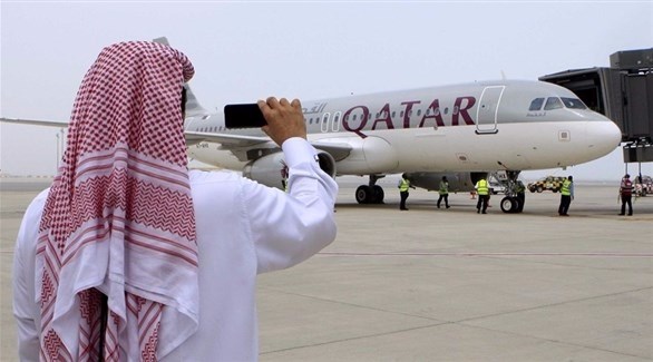 رجل بملابس خليجية يلتقط صورة لطائرة تابعة للخطوط الجوية القطرية (أرشيف)
