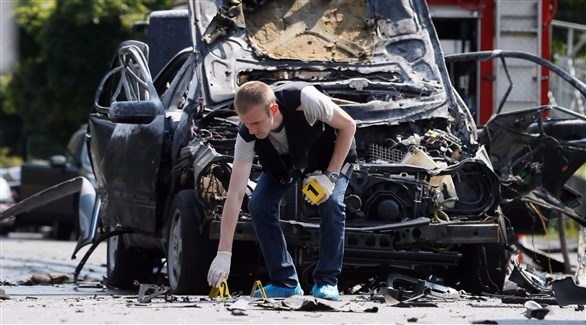 محقق يعاين المكان الذي انفجرت فيه السيارة بكييف (رويترز)