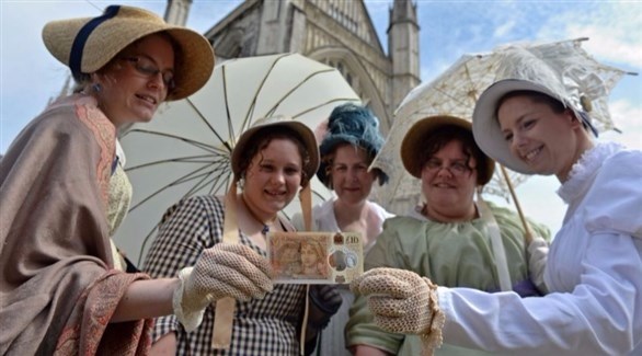 نساء يمسكن العملة النقدية الجديدة التي تحمل صورة جين أوستن