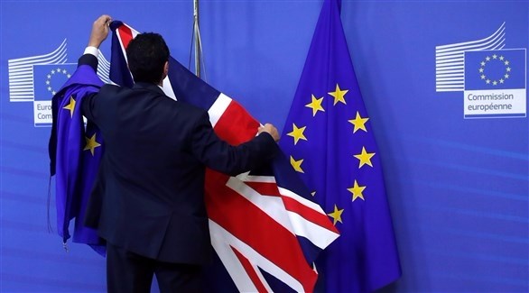 رجل يصلح العلم البريطاني إلى جانب علم الاتحاد الاوروبي (رويترز)