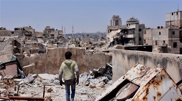 ولد سوري يتفقد منزلاً مدمراً في حلب.(أرشيف)