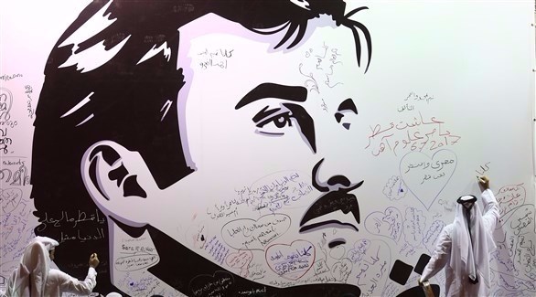 شخص يكتب على صورة عملاقة لأمير قطر، في الدوحة (أ ف ب)