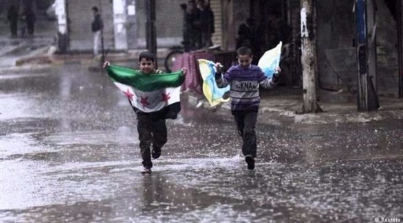 ولدان سوريان يحملان علم المعارضة السورية.(أرشيف)