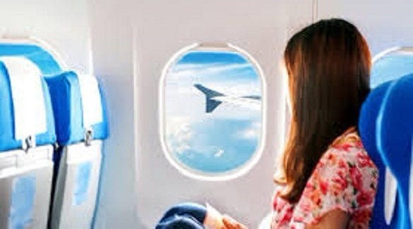 مسافرة تنظر إلى جناح الطائرة من النافذة (أرشيف)