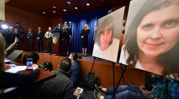النائب العام مايك هسترين في مؤتمر صحافي مع صور الضحايا (أ ف ب)