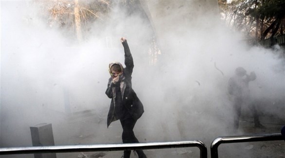 متظاهرة إيرانية بين دخان قنابل دخانية أطلقتها الشرطة الإيرانية.(أرشيف)