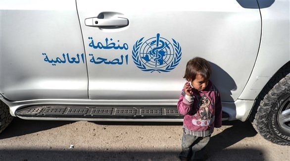 طفل يقف بجوار مركبة تابعة لمنظمة الصحة العالمية في الغوطة الشرقية (إي بي أيه)