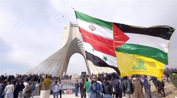 رجل يحمل أعلام إيران وسوريا وفلسطين وحزب الله في طهران.(أرشيف)