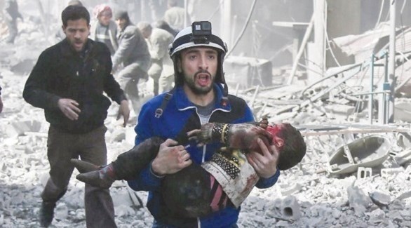 مسعف من الخوذ البيضاء ينقذ طفلاً مصاباً جراء قصف للنظام على الغوطة الشرقية (أرشيف)