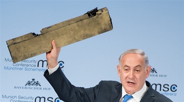 رئيس الوزراء الإسرائيلي بنيامين نتانياهو حاملاً قطعة من الدرون الإيرانية، في مؤتمر ميونيخ للأمن.(رويترز)