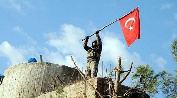 جندي تركي يرفع علم بلاده في عفرين (أرشيف)