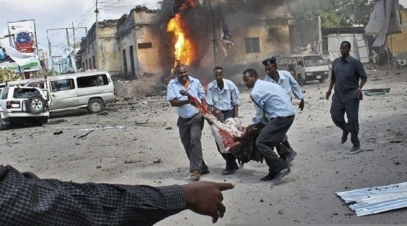 شرطيون صوماليون يحاولون إسعاف ضحية تفجير سابق في مقديشو (أرشيف)