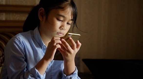طفلة تستخدم هاتفا محمولاً (أرشيف) 