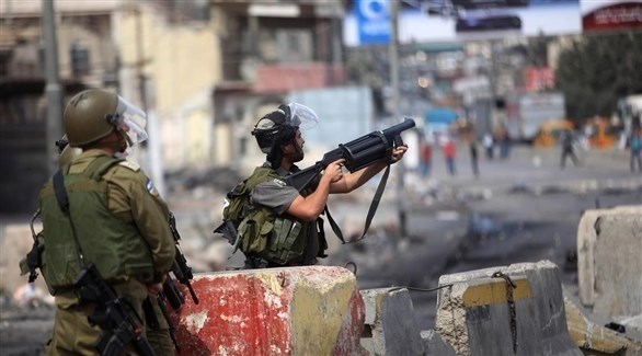 جندي إسرائيلي يُطلق غازاً مسيلاً للدموع على محتجين فلسطينيين في الضفة الغربية (أرشيف) 