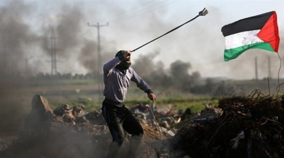 محتج فلسطيني يلقي حجارة على القوات الإسرائيلية في غزة (أب)
