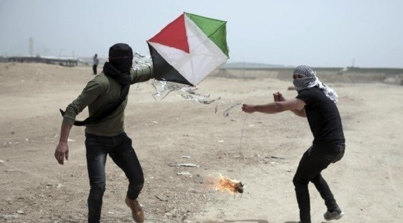 فلسطينيان يحملان طائرة ورقية في غزة بمواد حارقة (أرشيف)