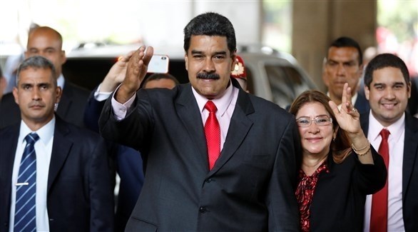 الرئيس الفنزويلي مادورو يحيي أنصاره إلى جانب زوجته سيليا فلوريس بعد فوزه في الانتخابات (رويترز)