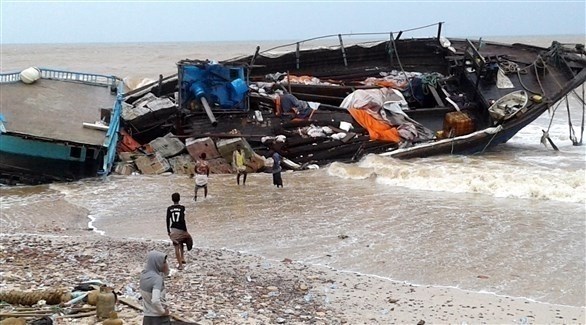 يمنيون يعاينون حطام سفينة تضررت من الإعصار