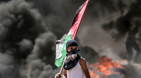 فلسطيني يحمل علم بلاده خلال مواجهات "مسيرات العودة".(أرشيف)