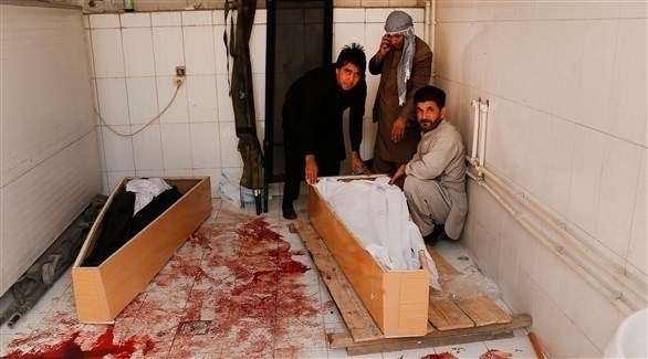 أقراب يجلسون بجانب جثث أفراد عائلاتهم في أفغانستان (اي بي ايه)