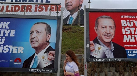 امرأة تمر بجانب صور عملاقة للرئيس أردوغان (اي بي ايه)
