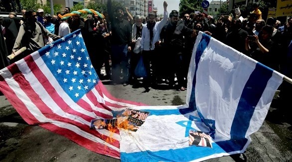 إيرانيون يحرقون علمين أمريكياً وإيرانياً في طهران (أب)