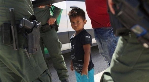 طفل مهاجر في الولايات المتحدة محاطاً بحرس الحدود الأمريكيين (تويتر)  