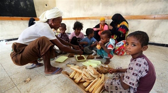 عائلة يمنية تتناول الفطور في مدرسة بعد إجلائها من قرية قرب مطار الحديدة (أرشيف)