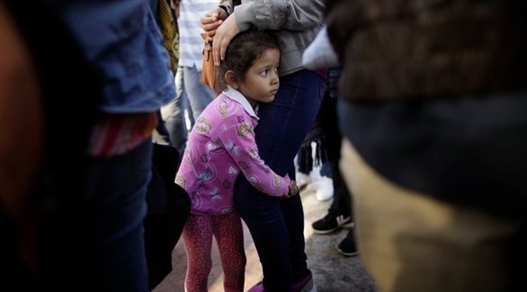 طفلة ن أمريكا اللاتينية تتمسك بأمها على الحدود الأمريكية المكسيكية (أرشيف)