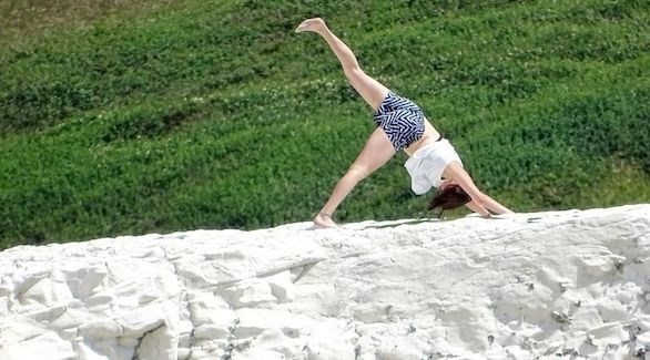 تخاطر بحياتها بممارسة اليوغا على حافة جرف صخري هش (ميرور)
