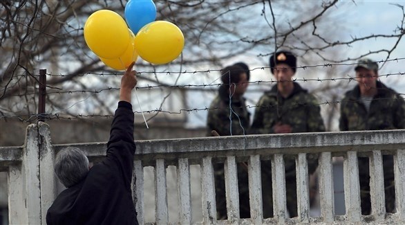 أوكراني مؤيد لكييف يرفع بالونات أمام جنود أوكرانيون في شرق البلاد.(أرشيف)
