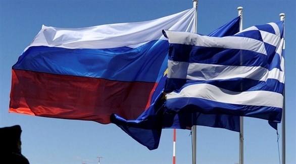 العلمان الروسي واليوناني يتوسطهما علم الاتحاد الأوروبي (أرشيف)