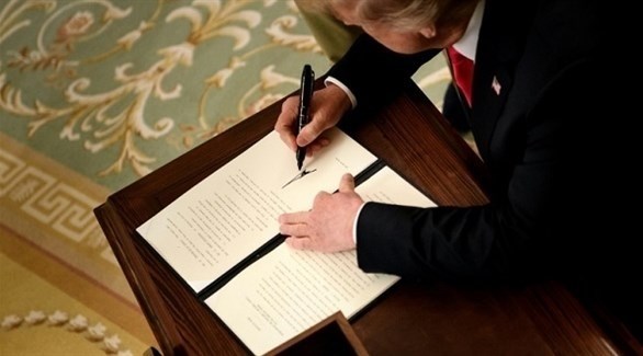 الرئيس الأمريكي دونالد ترامب أثناء توقيعه مذكرة الرسوم الجمركية على واردات الصلب (أ ف ب)