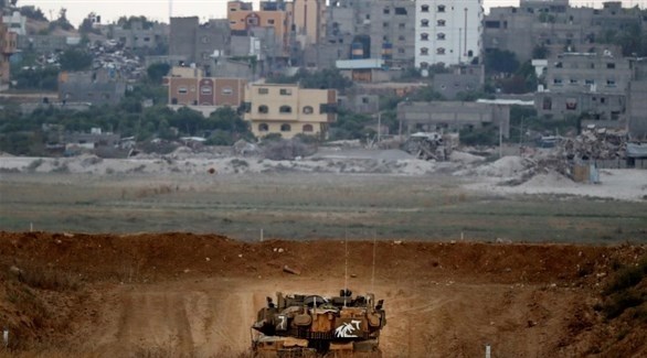 دبابة إسرائيلية تراقب غزة من خلف ساتر ترابي على الحدود (أ ف ب)  