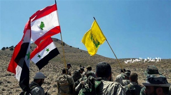 مقاتلون من حزب الله برفعون أعلام الجزب ولبنان وسوريا.(أرشيف)