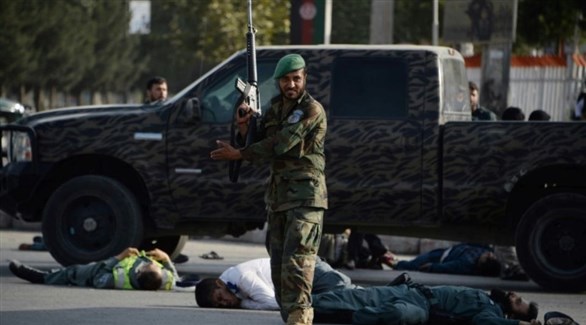 رجل أمن أفغاني قرب المطار بعد الهجوم الانتحاري وسط ضحايا ومصابين (أ ف ب)  