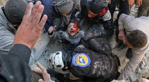 رجال من "الخوذ البيض" يسعفون طفلا أصيب في القصف.(أرشيف)
