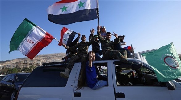 مقانلون يحملون أعلام سوريا وإيران في سوريا.(أرشيف)
