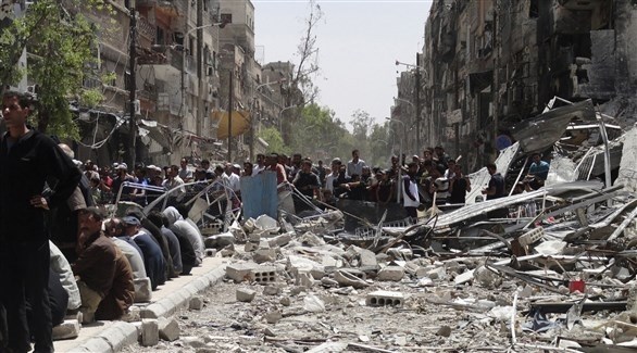سوريون بين أنقاض أحد الشوارع (أرشيف)