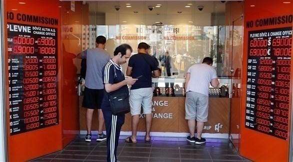 اشخاص يقفون أمام واجهة أحد متاجر الصيرفة في اسطنبول (رويترز)