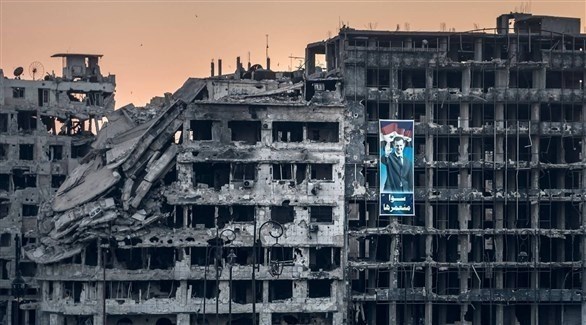 صورة لرأس النظام بشار الأسد على دمار الأبنية السكنية في حمص (أرشيف)
