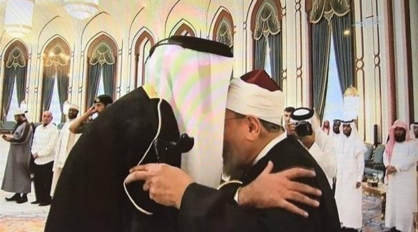 أمير قطر الشيخ تميم مقبلاً جبين الداعية يوسف القرضاوي.(ارشيف)