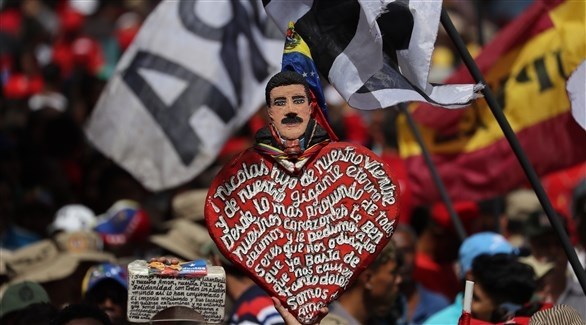 متظاهرون يحملون قلوباً عليها صورة مادورو في تجمع بكراكاس (اي بي ايه)