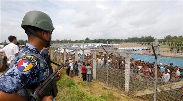 حارس حدود بورمي يراقب عدداً من لاجئي الروهينجا (إ ب أ)