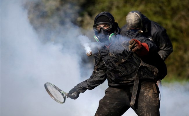 محتج يستخدم مضرب تنس لإعادة عبوة غاز مسيلة للدموع خلال مواجهات بين الدرك الفرنسي ومعتصمين 